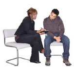 Man and woman sitting on chairs looking through written information