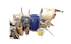 A pile of equipment including a wheelbarrow, cement mixer and bricks A pile of equipment including a wheelbarrow, cement mixer and bricks
