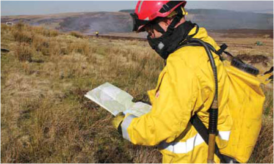 Photo B10.5 A trained firefighter using an OS map to identify features on the landscape