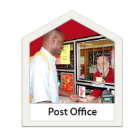 Customer at post office counter, handing over envelope to the post office member of staff