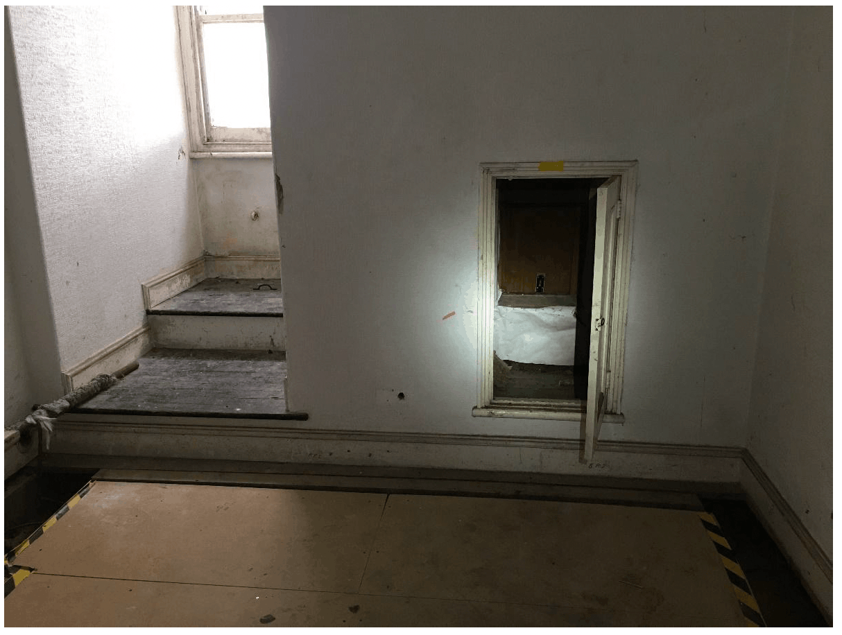 Door to eaves of a mansard roof with gutter under the window seat
