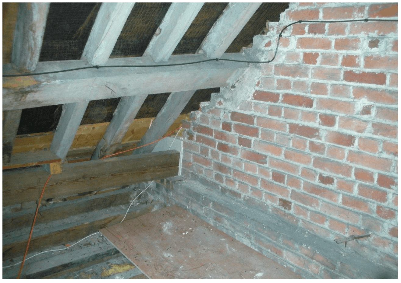 Inadequate fire protection at junction of separating wall with roof
