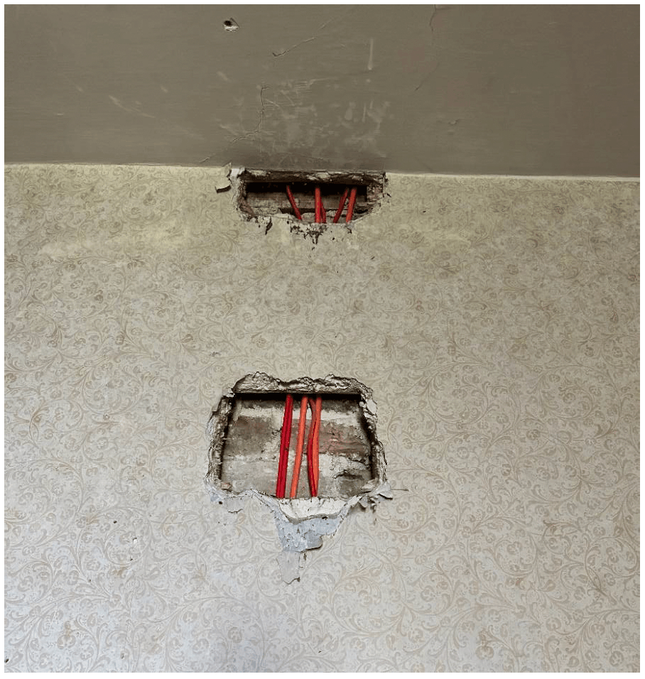 Cavity behind lath and plaster with cables rising through ceiling