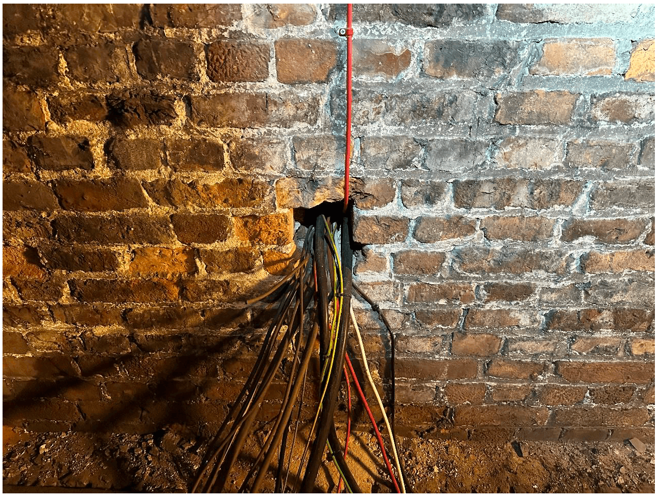 Building services penetrating a masonry wall acting as a separating wall.