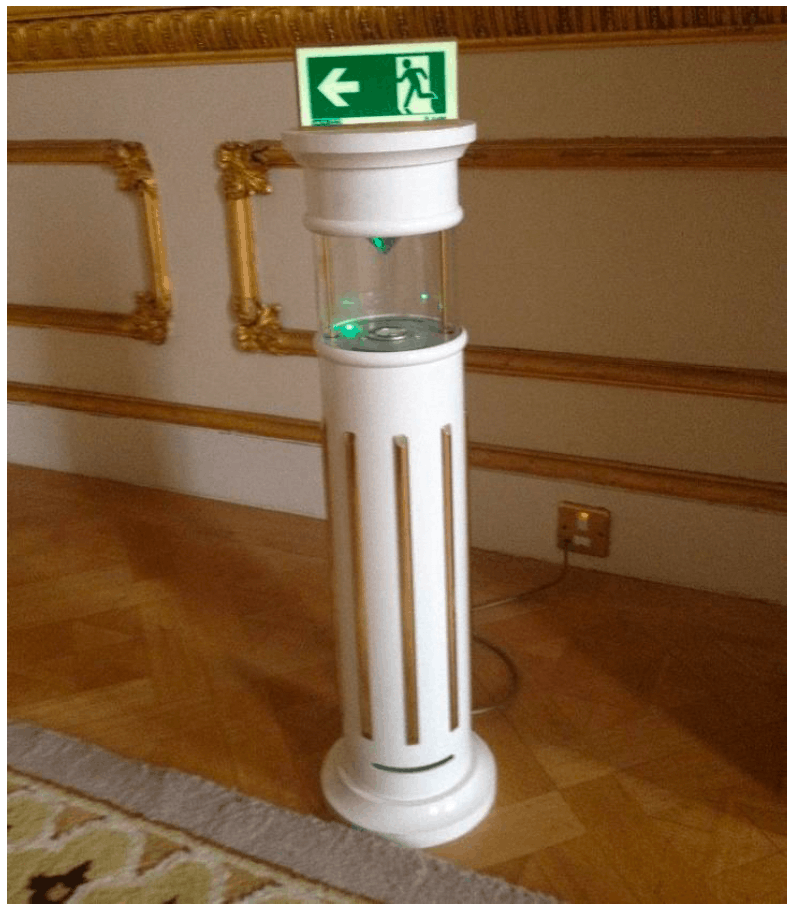 A white column with an emergency exit sign