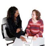 Two women discussing a form on a table