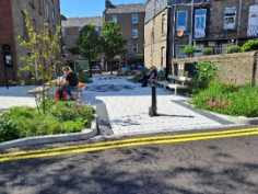 Craigie Street Pocket Park
Image shows a paved street with multiple plant beds and trees on either side of the pavement.