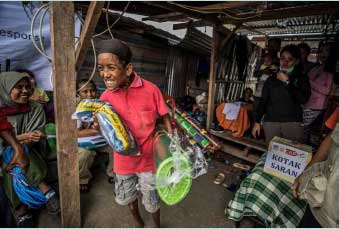 Fifteen year old Gesang* collects a shelter kit for his family following the Indonesian Tsunami. Fifteen year old Gesang* collects a shelter kit for his family following the Indonesian Tsunami.