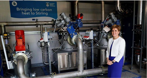 Picture showing the First Minister next to heat pumps