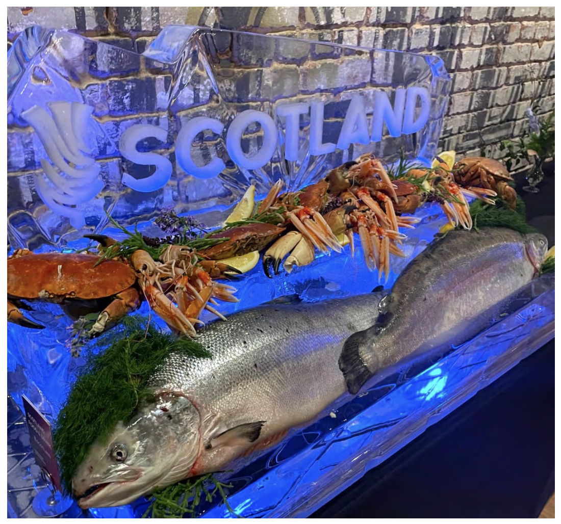 An ice sculpture engraved with Scotland marque, with Scottish seafood displayed beside it.