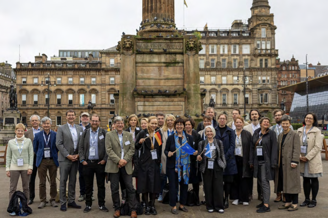 A group of people stand in front of a historic building.