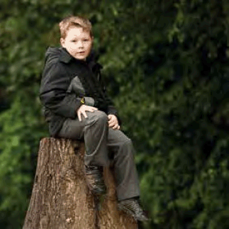 boy sitting on a tree stump