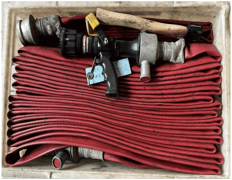 The photo is of a legacy service high rise equipment box showing firefighting equipment and hose stowed in a flaked format.