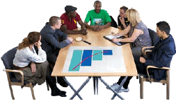 a group of people sitting at a table working together