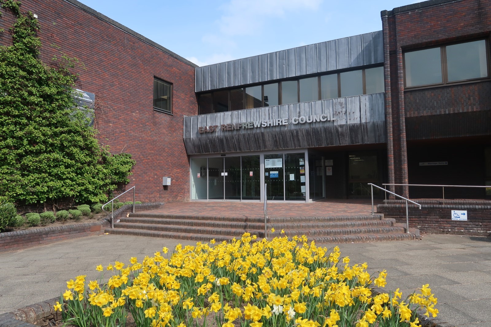 East Renfrewshire Council building with yellow flowers in front of it