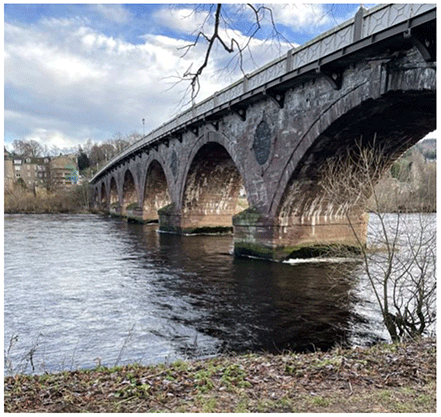 Image of a bridge crossing the River Tay taken from the river bank.