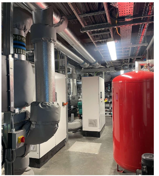 A room with heat pumps and water storage tanks. 