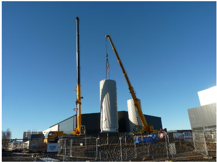 A crane lifting a cylindrical object
