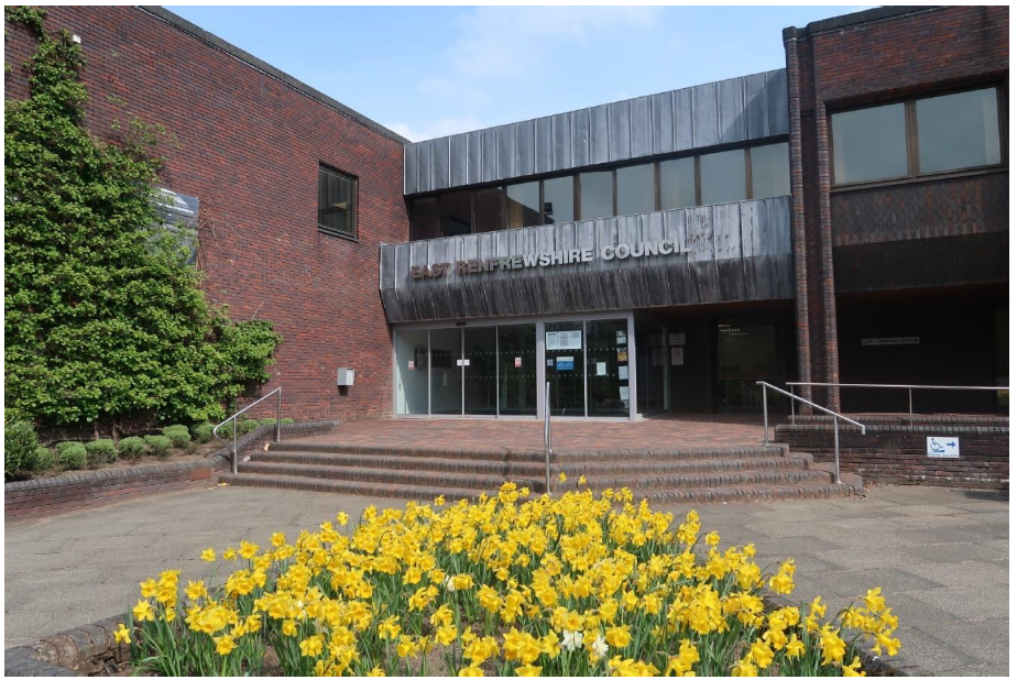 East Renfrewshire Council building with yellow flowers in front of it

