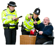 A person in a wheelchair pointing and speaking to two police officers. One police officer is pointing and the other one is writing