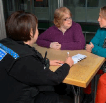 Two women speaking to a female police officer