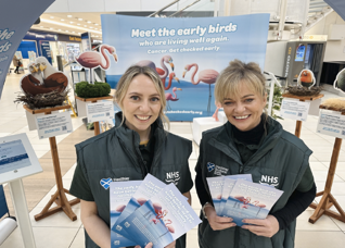 Image of two women holding
campaign materials at a roadshow
event