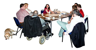 A group of supported people sit round a table planning something
