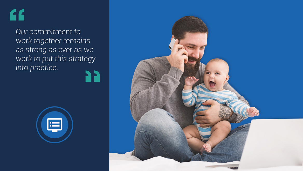 Image of father holding his child and using a laptop