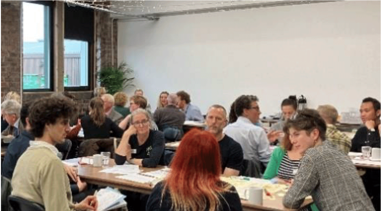 A group of people sitting at tables from one of the engagement workshops.