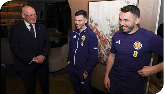 First Minister John Swinney laughs with two Scotland men’s team footballers, Andy Robertson and John McGinn 