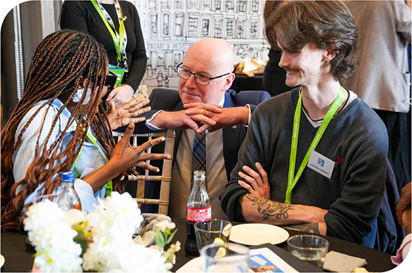First Minster John Swinney chats to two young people round a table at an event for the First Minister’s Start Up Challenge 